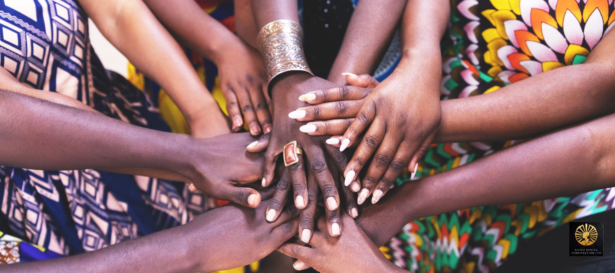 A circle of women's hands stacked together in solidarity